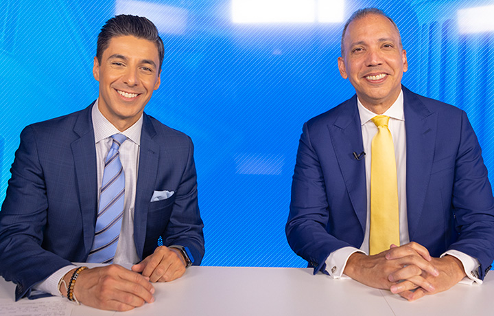 Commissioner Louis Molina and PIX11 Dan Mannarino sitting at a news desk with a blue background.
                                           