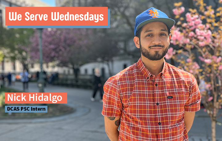 Bearded young man wearing a red plaid shirt and blue and orange Mets ball cap near a court building.
                                           