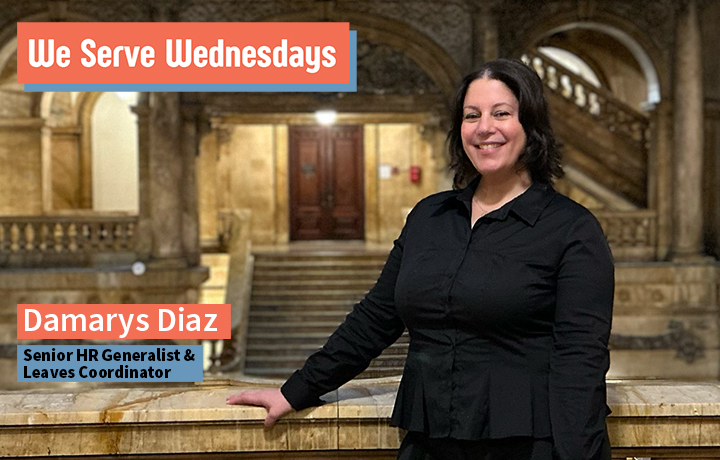 Woman standing in NYC Surrogate Court Building smiling wearing a black shirt.
                                           