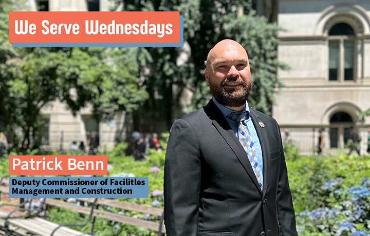 Man standing outside in City Hall Park wearing a suit.
                                           