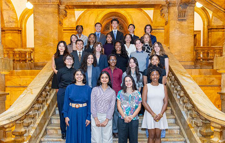 25 people standing on a staircase in the lobby of 31 Chambers Street.