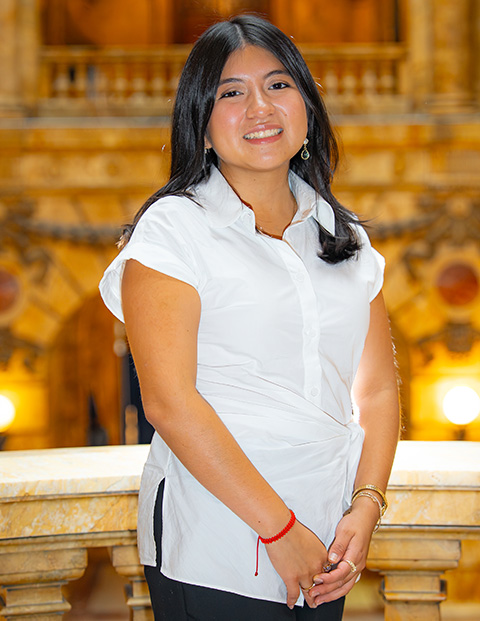 Person smiling, wearing a white shirt and black pants.
