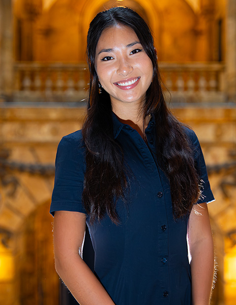 Person smiling, wearing a blue dress.