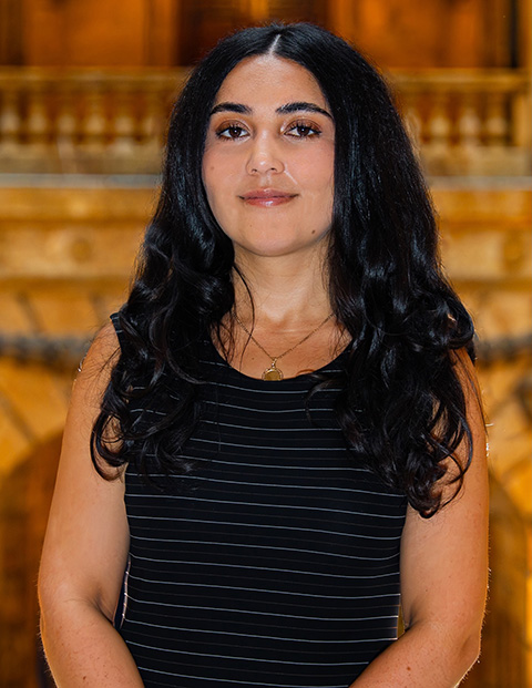 Person smiling, wearing a black striped shirt.