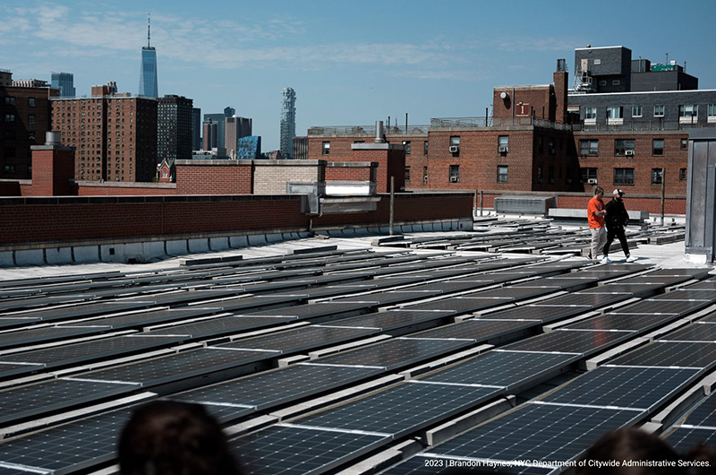 Solar panels on roof top of building with lower Manhattan view in the background