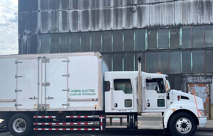 Hybrid electric truck outfitted with rail-style sideguard.
                                           