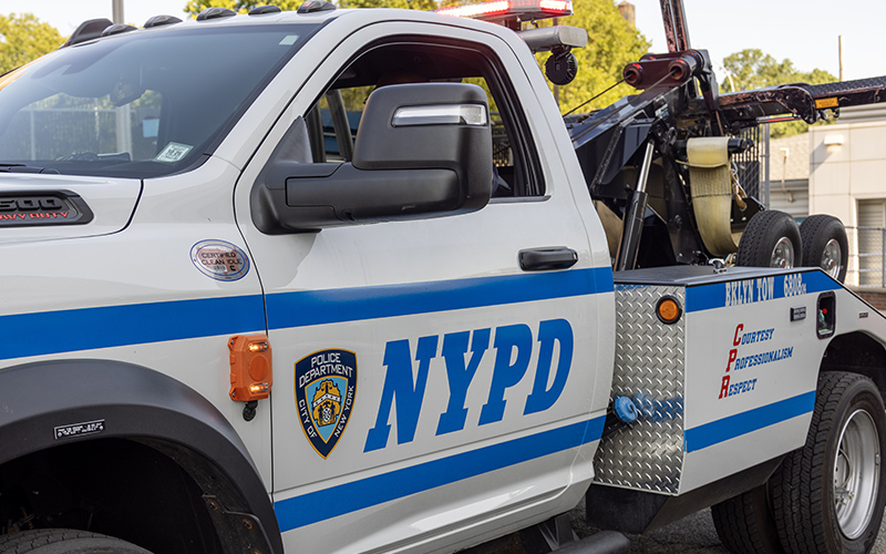 NYPD tow truck featuring pedestrian turn alert technology.