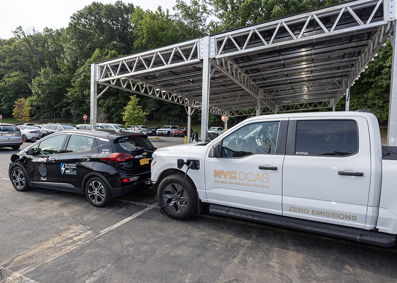 DCAS electric vehicles parked in front of the solar canopy at Michael J. Petrides School, Staten Island.