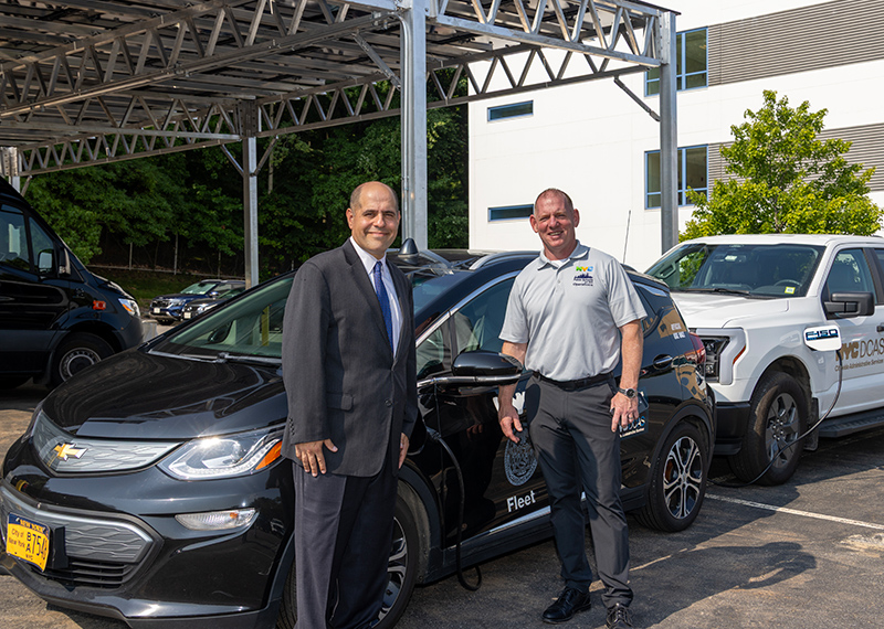 DCAS Deputy Commissioner and NYC Chief Fleet Officer Keith Kerman and NYCPS Deputy Chancellor Kevin Moran stand in front of the newly installed solar canopy.