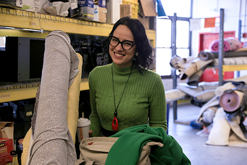 Shopper smiles pushing a cart of fabric in the MFTA warehouse.