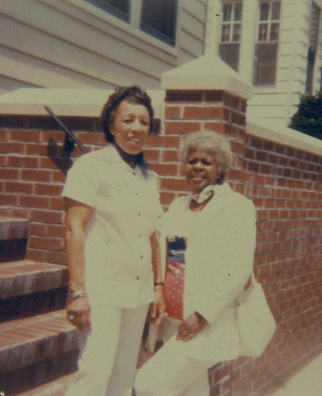 Selma Heraldo and Lucille Armstrong smile for a photo in the neighborhood. 