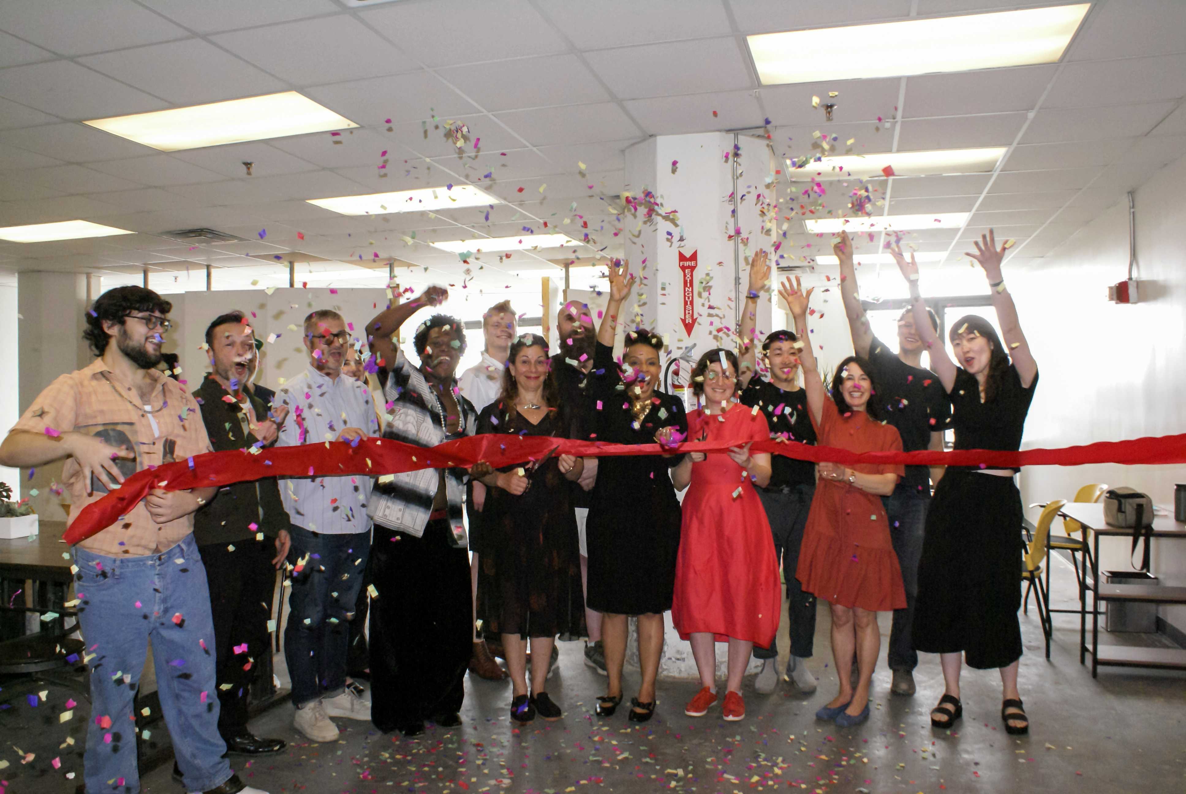 DCLA, MFTA, CO Adaptive, and partners hold a red ribbon and throw confetti.   