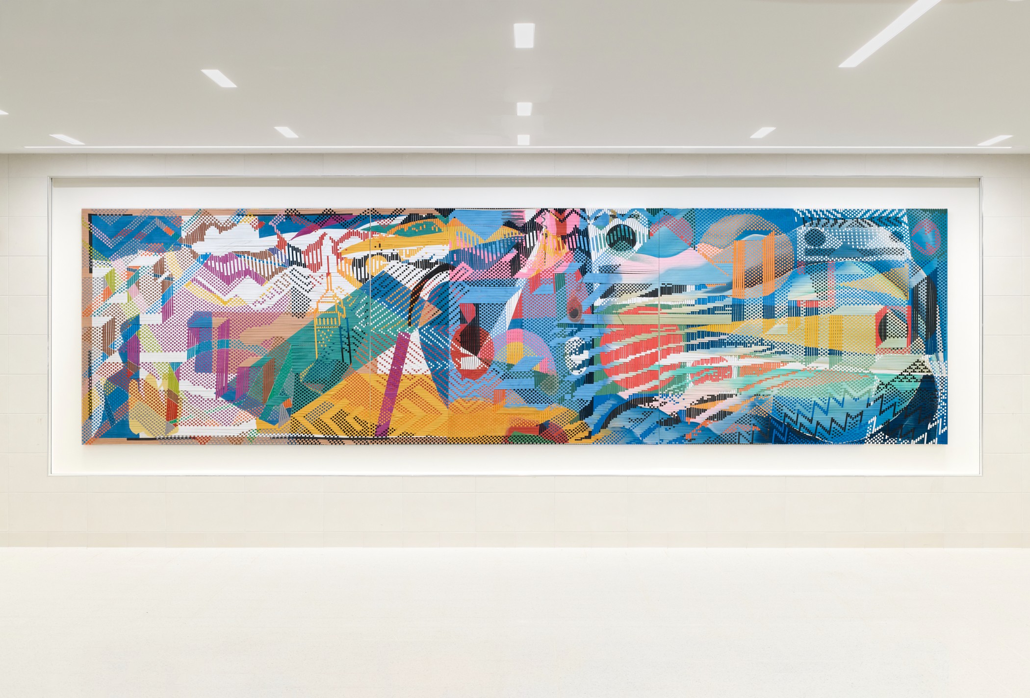 A woven mural with cool colors and geometric shapes in the school hallway