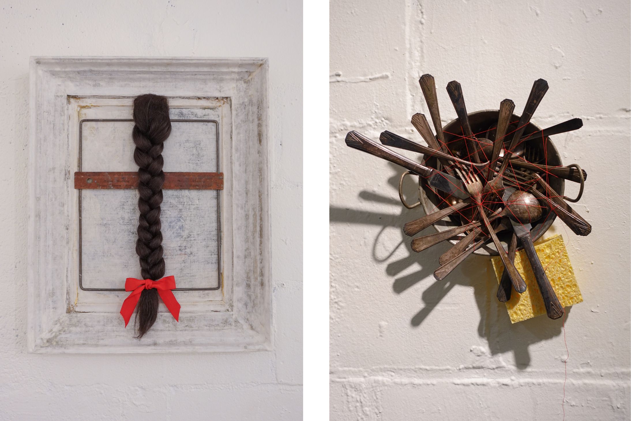A framed, braided ponytail with a bow. Silverware in a sponge with red thread.