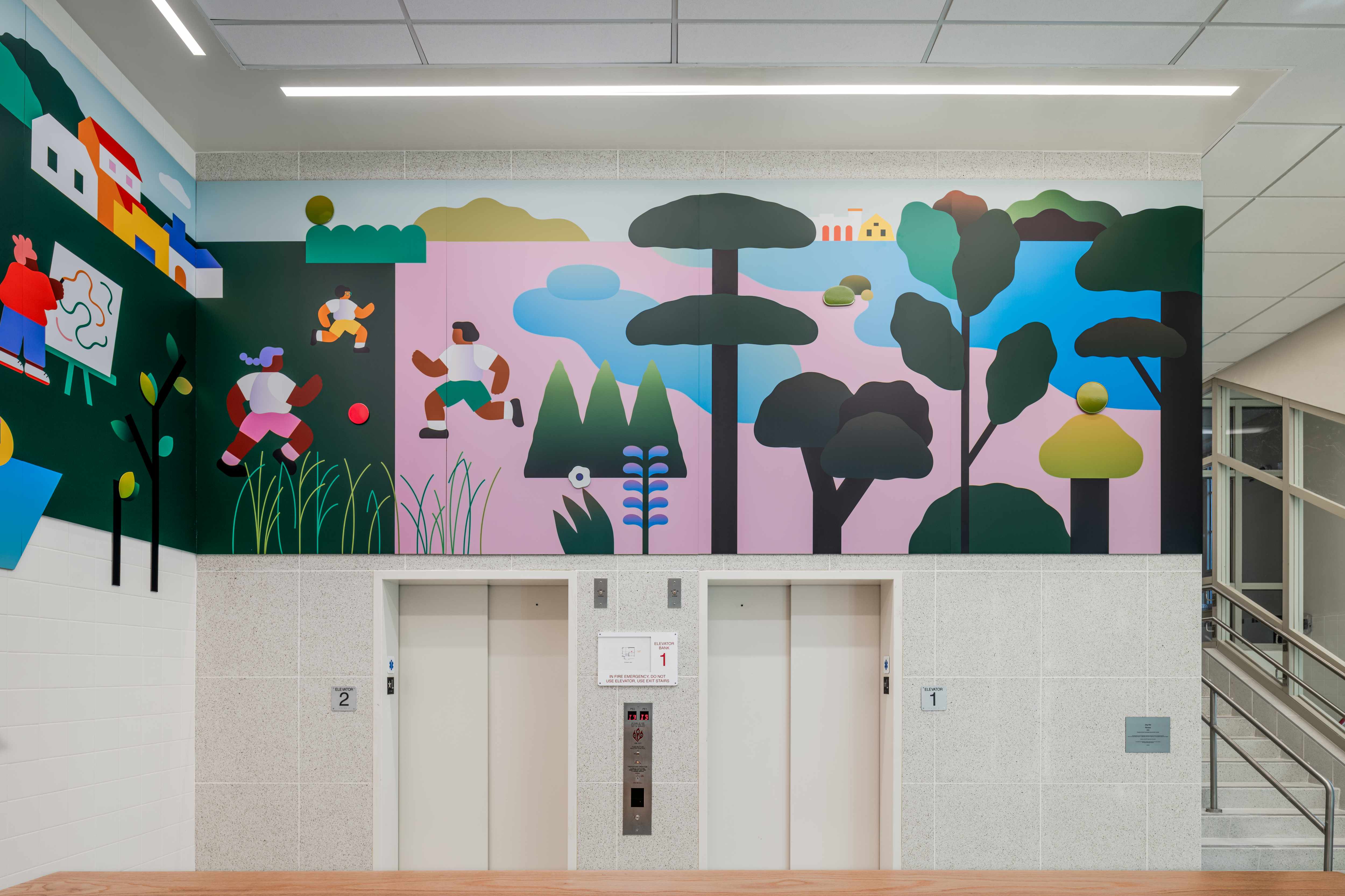 An installation in a school lobby of people playing and making art in nature. 