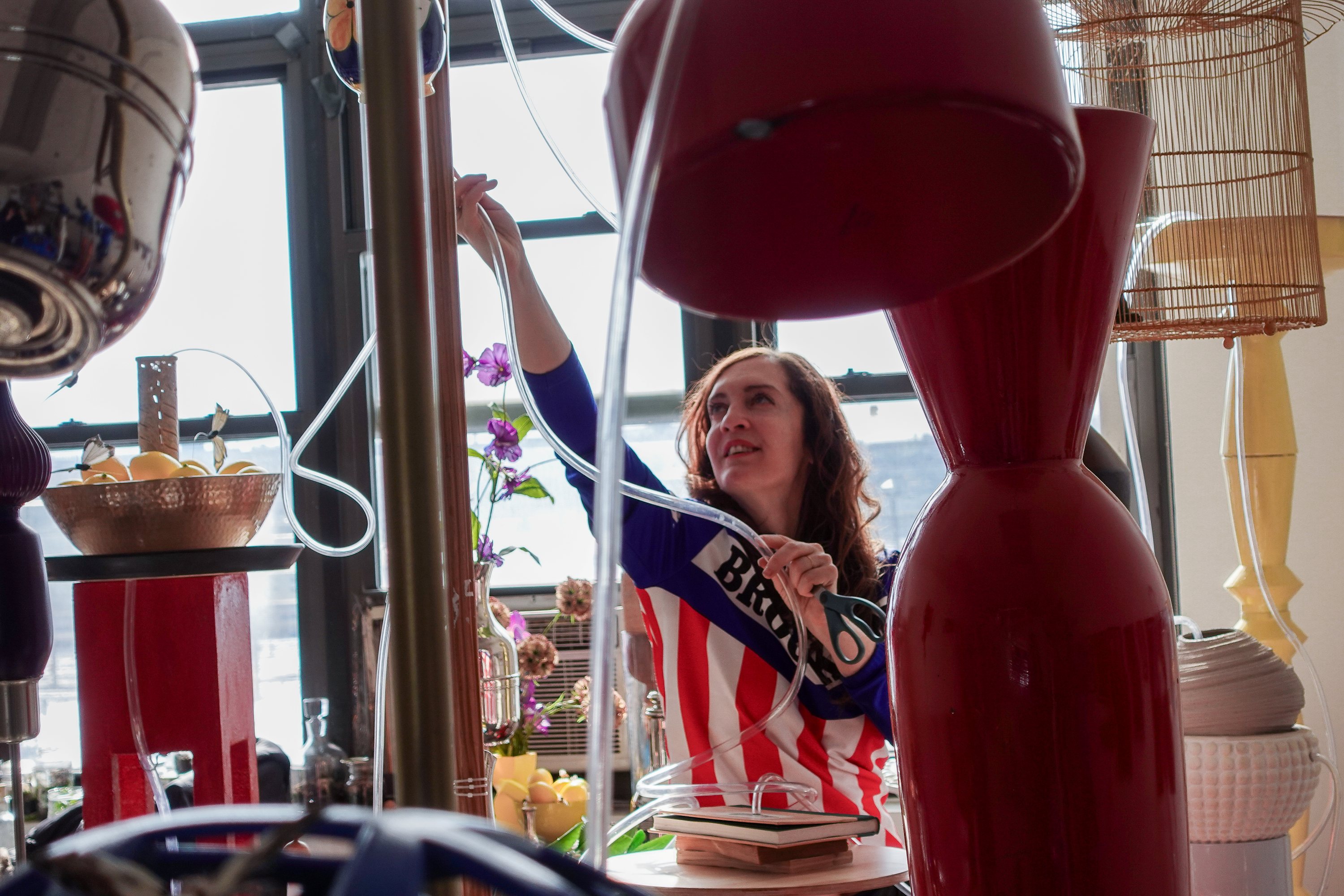 Mary Mattingly strings tubing through an installation in the MFTA artist studio.