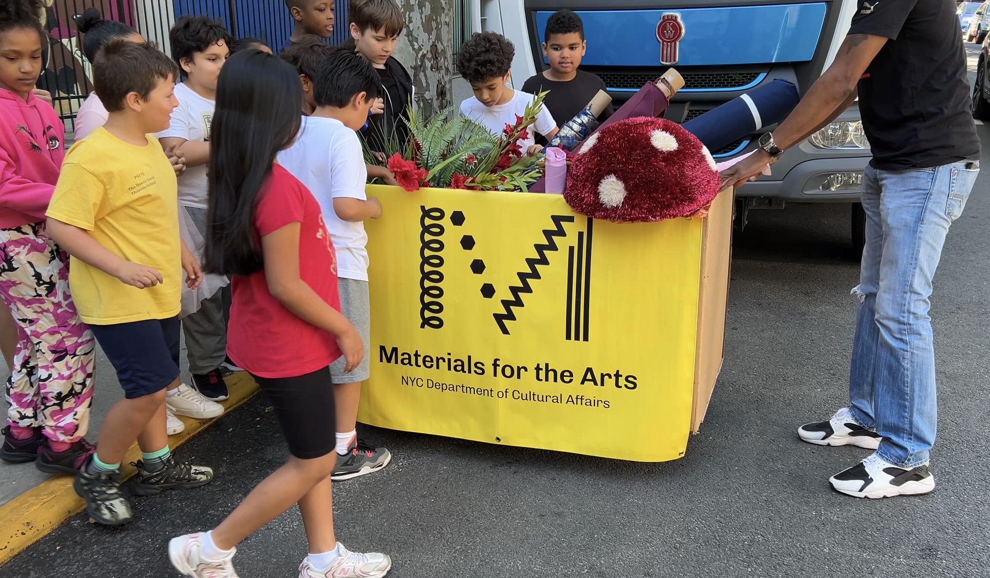 Students gather in front of a bin of supplies from the MFTA warehouse.
