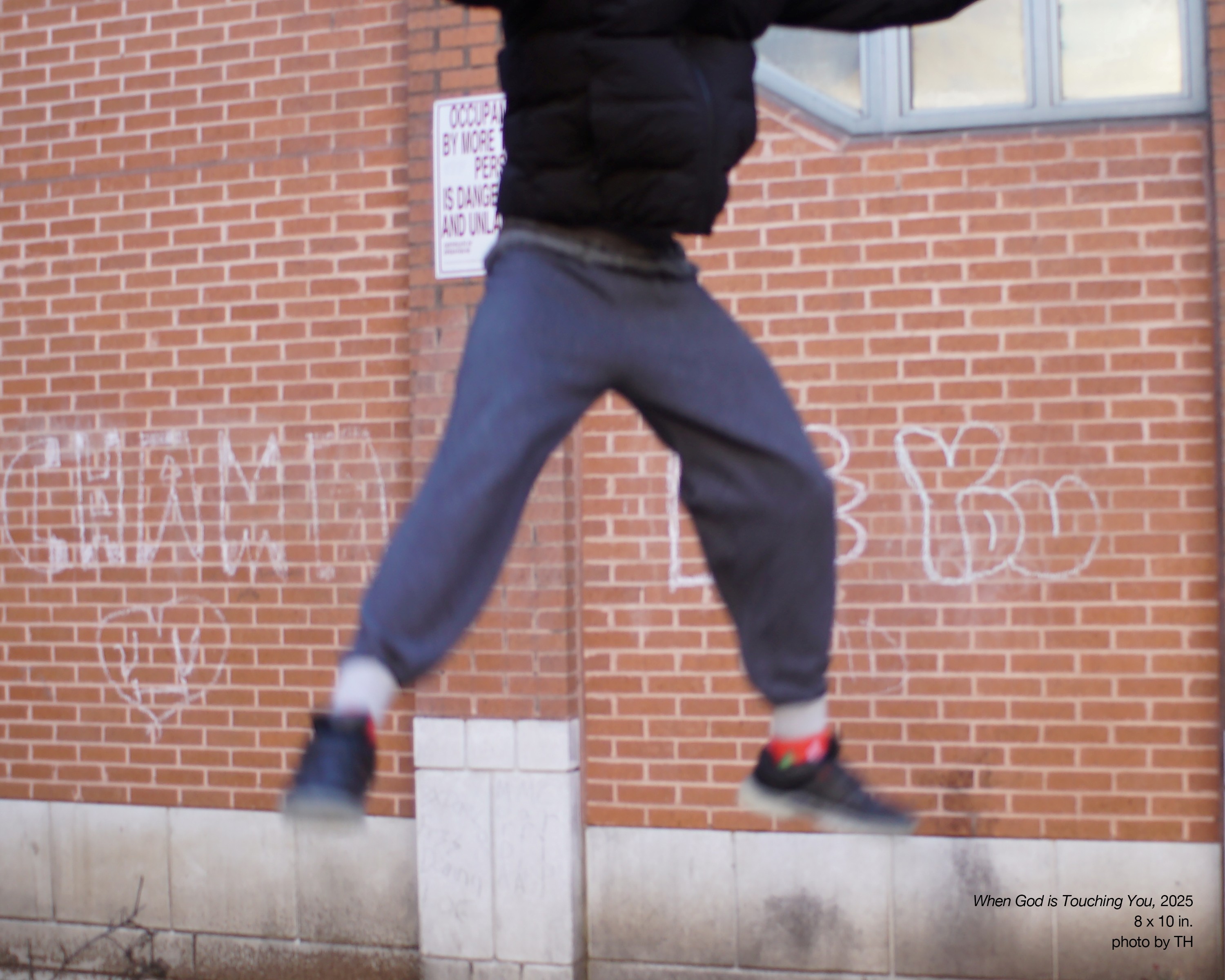 : A photo of a youth jumping up in the air and out of the frame of the photo