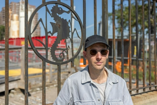 Carlos Irijalba stands next to the salvaged fence installation with a seahorse. 