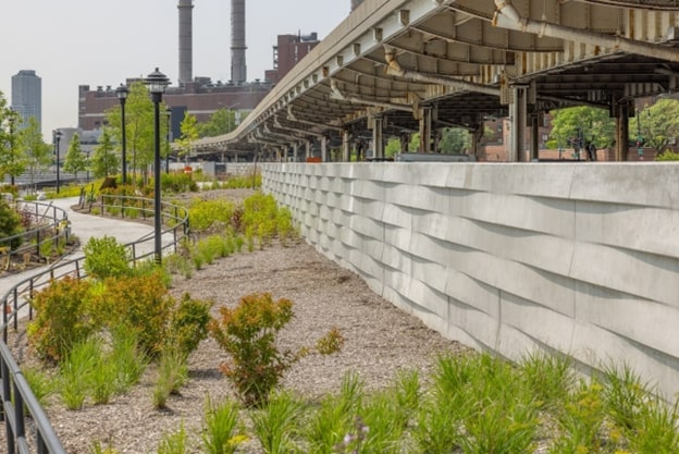 A structure with an awning, green plants, and a walking path. 