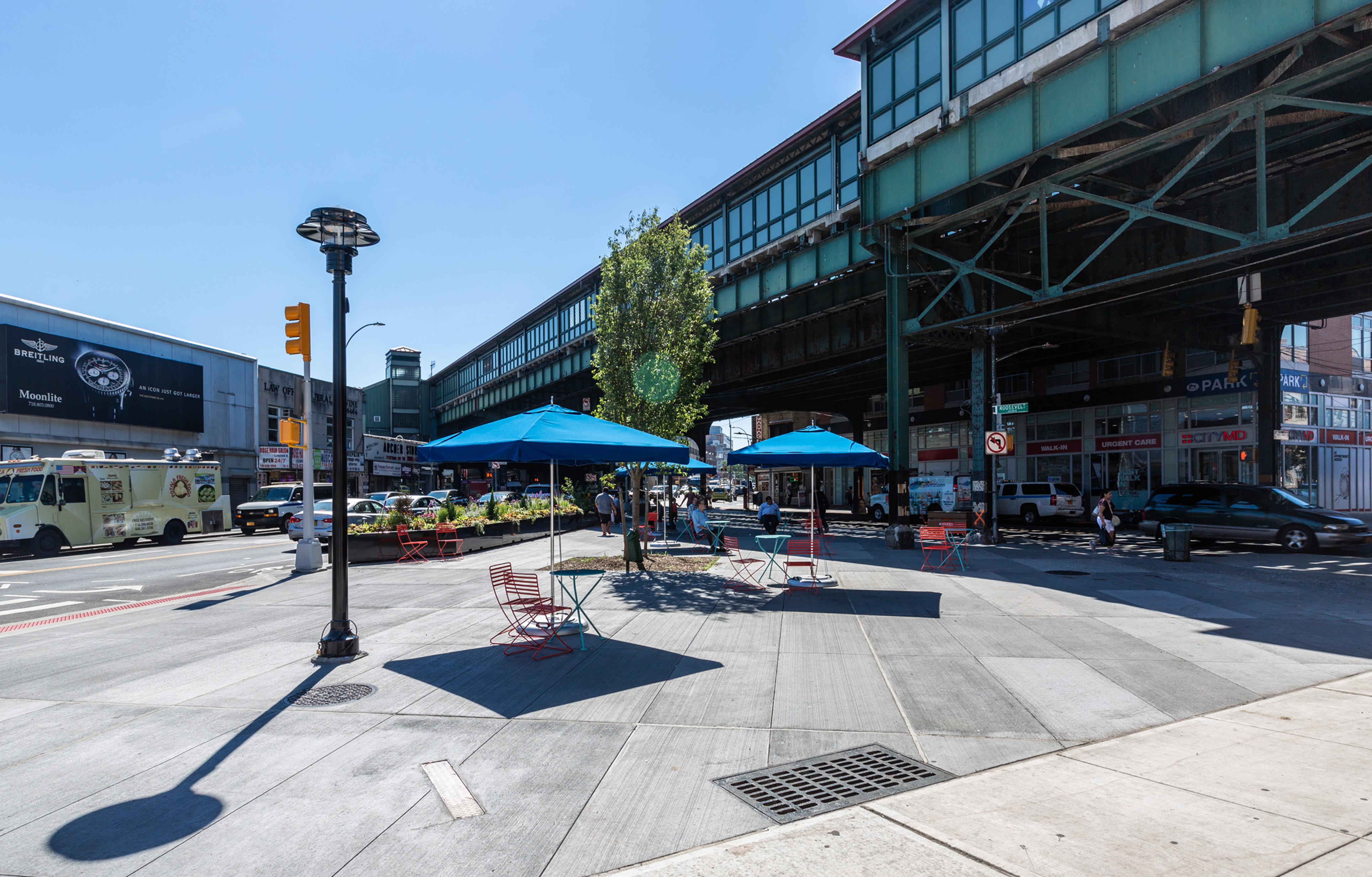 Diversity Plaza in Queens includes umbrellas, tables, and chairs
                                           