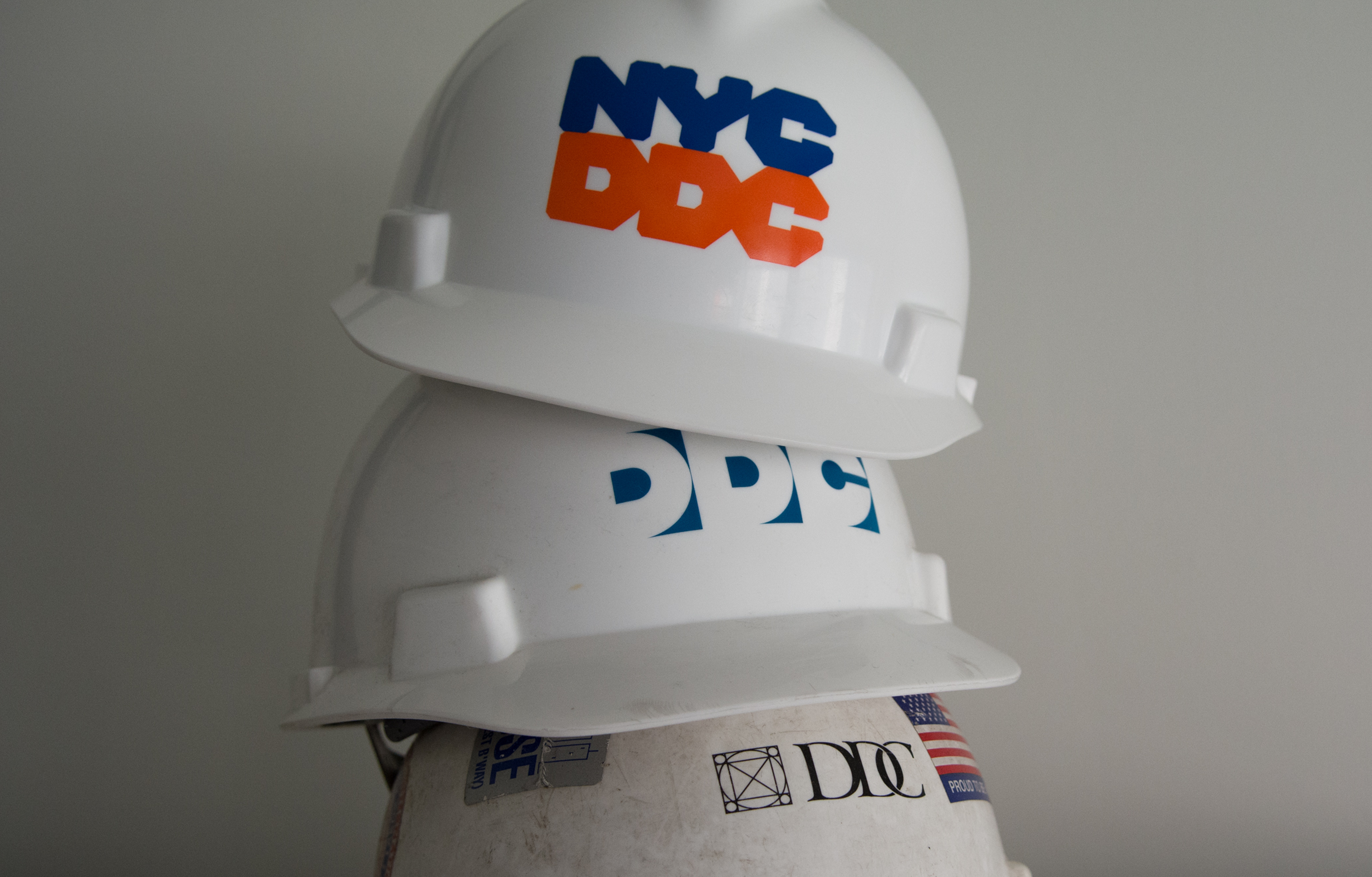 Three construction helmets stacked on top of one another
                                           