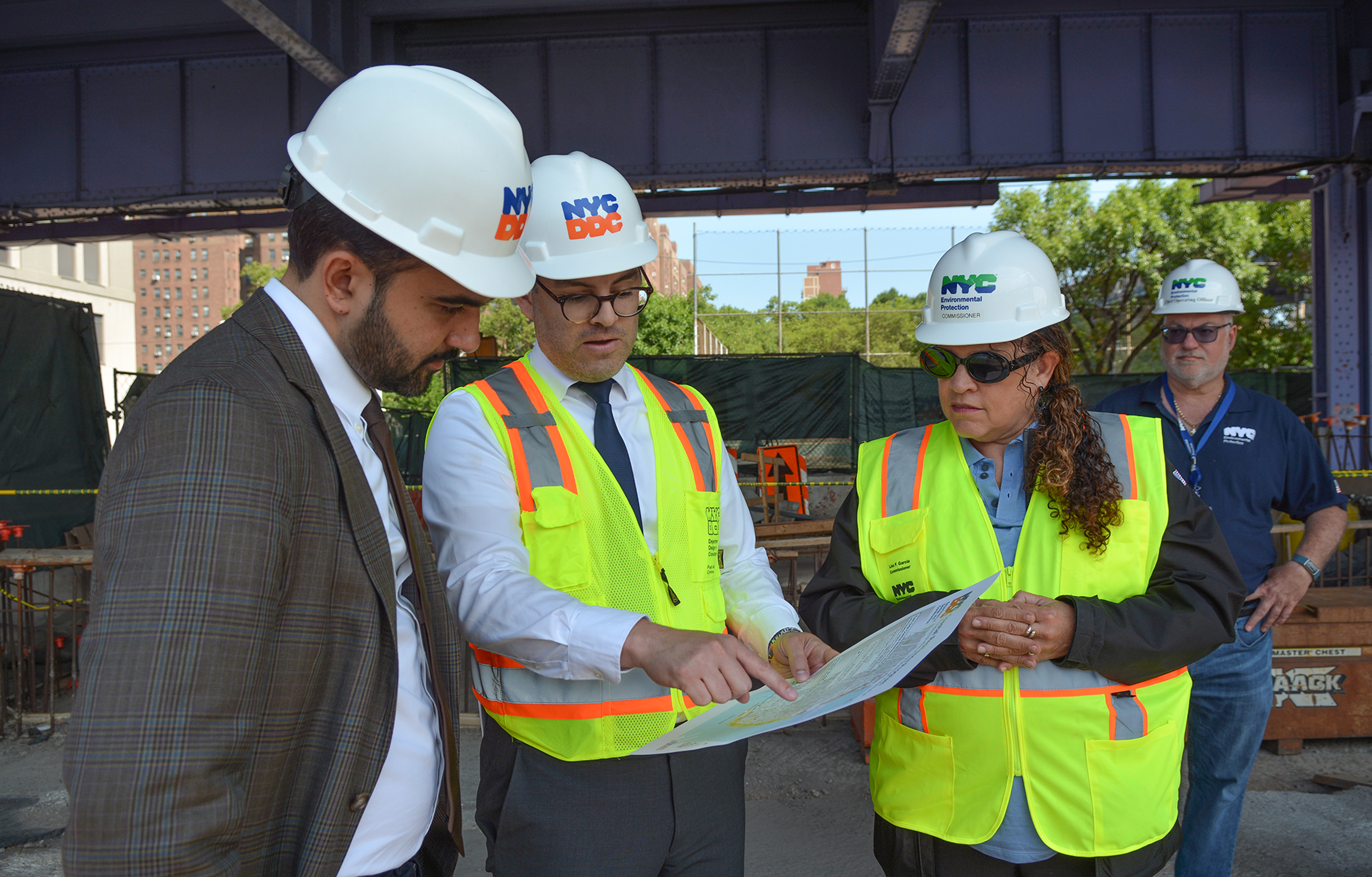 Mayor Mamdani and DDC and DEP commissioners stand together looking at a project map
                                           