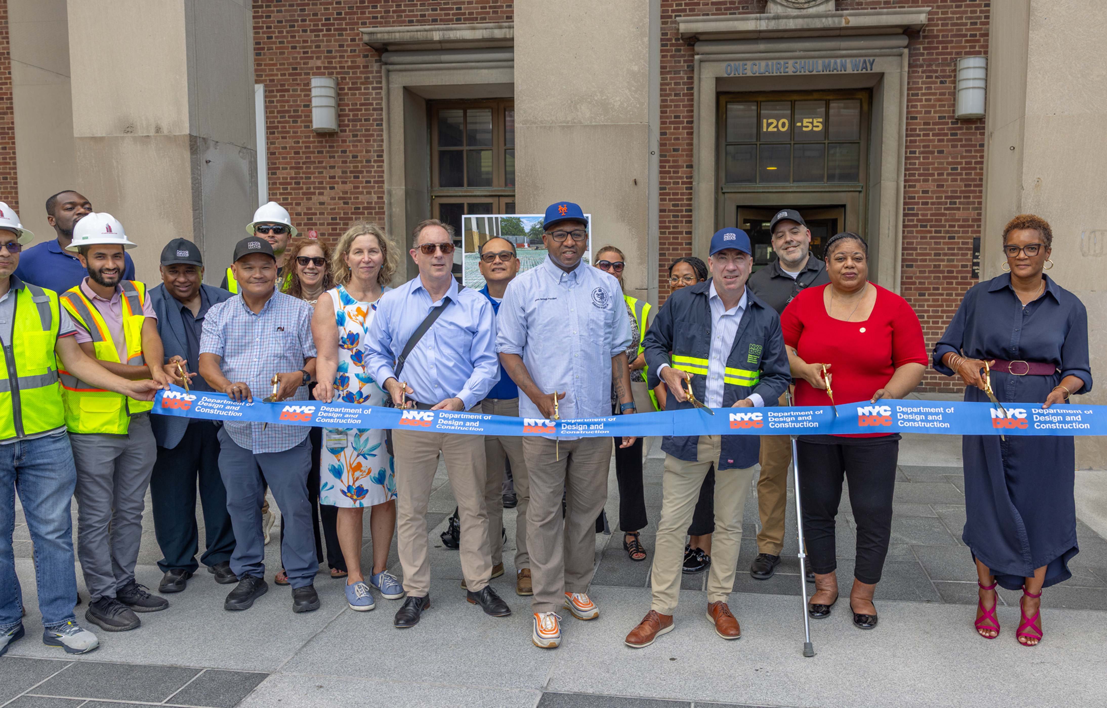 Group photo of city officials and project team members cutting ribbon
                                           