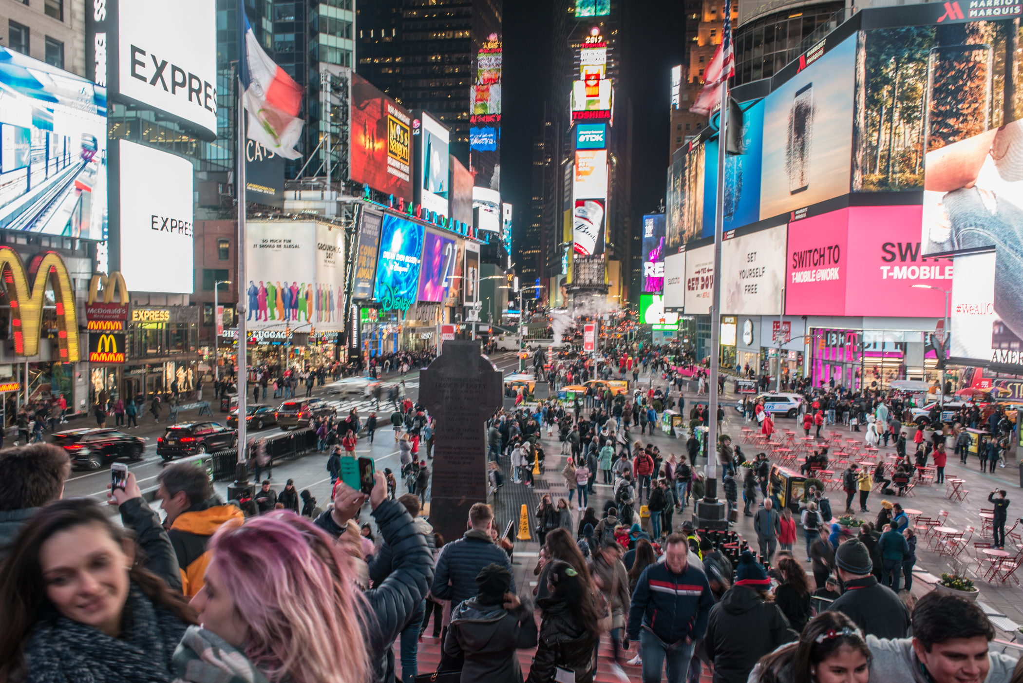 Crowds of people at Times Square Plaza at night