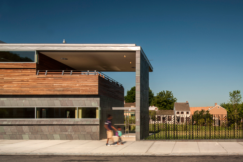 People walking along a path through the Weeksville Heritage Center.