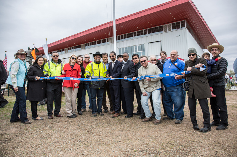 DDC staff prepare to cut the ribbon. The Riding Center is in the background.