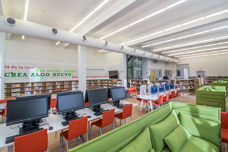 The interior of the Washington Heights Library. A computer room with bright furniture.