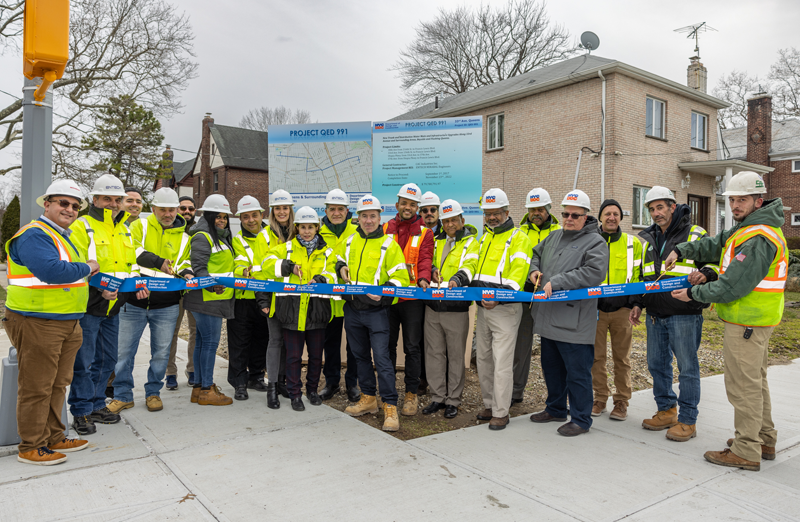 DDC Commissioner Thomas Foley (center), the DDC project team, consultants and contractors celebrate the completion of the $79.7 million project that rebuilt 3.5 miles of streets along 33rd, 37th and 38th Avenues