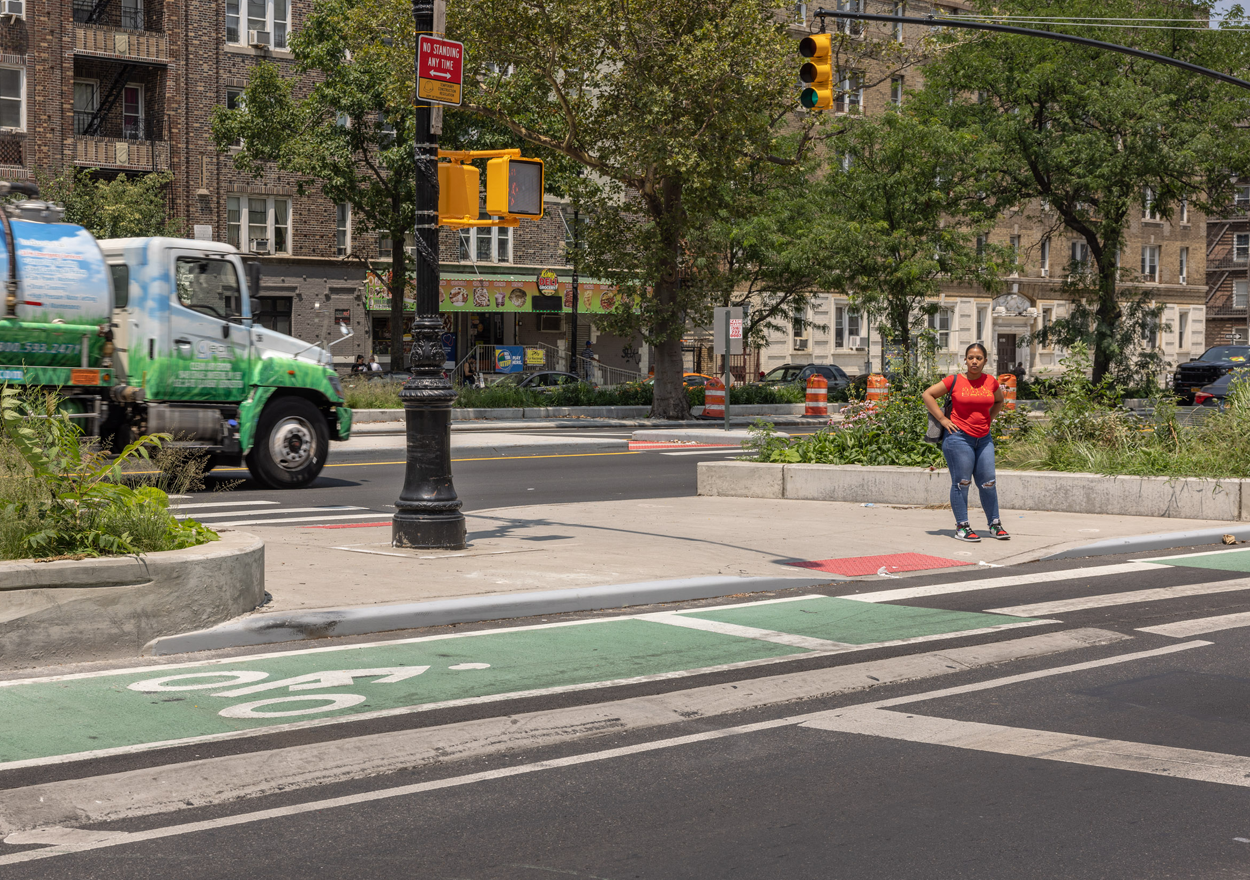 A pedestrian stands on sidewalk