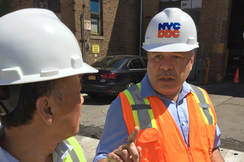 DDC Engineer-in-Charge Jatin Upadhyay, a 28-year veteran of City construction projects, talks to a crew member.