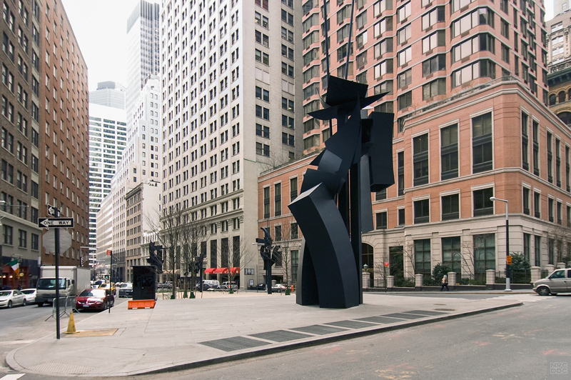 View of a tall, black sculpture in the middle of Louise Nevelson Plaza