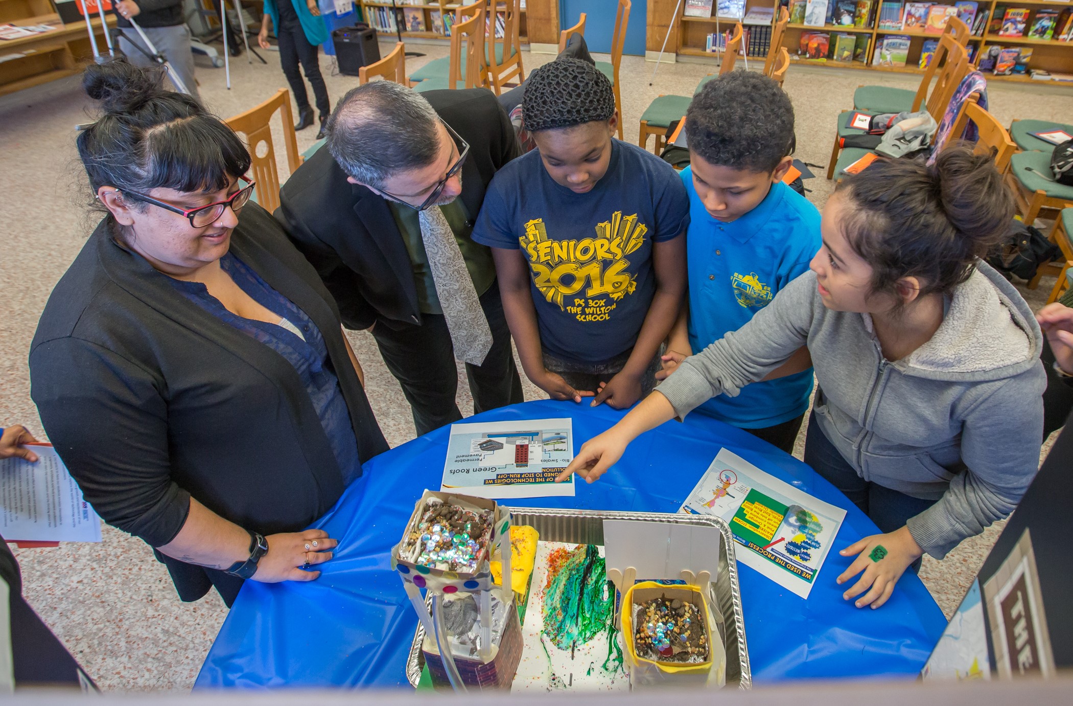 Students display their model cities and explain their projects to guests.