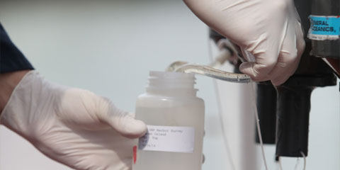 Hands drawing a water sample
