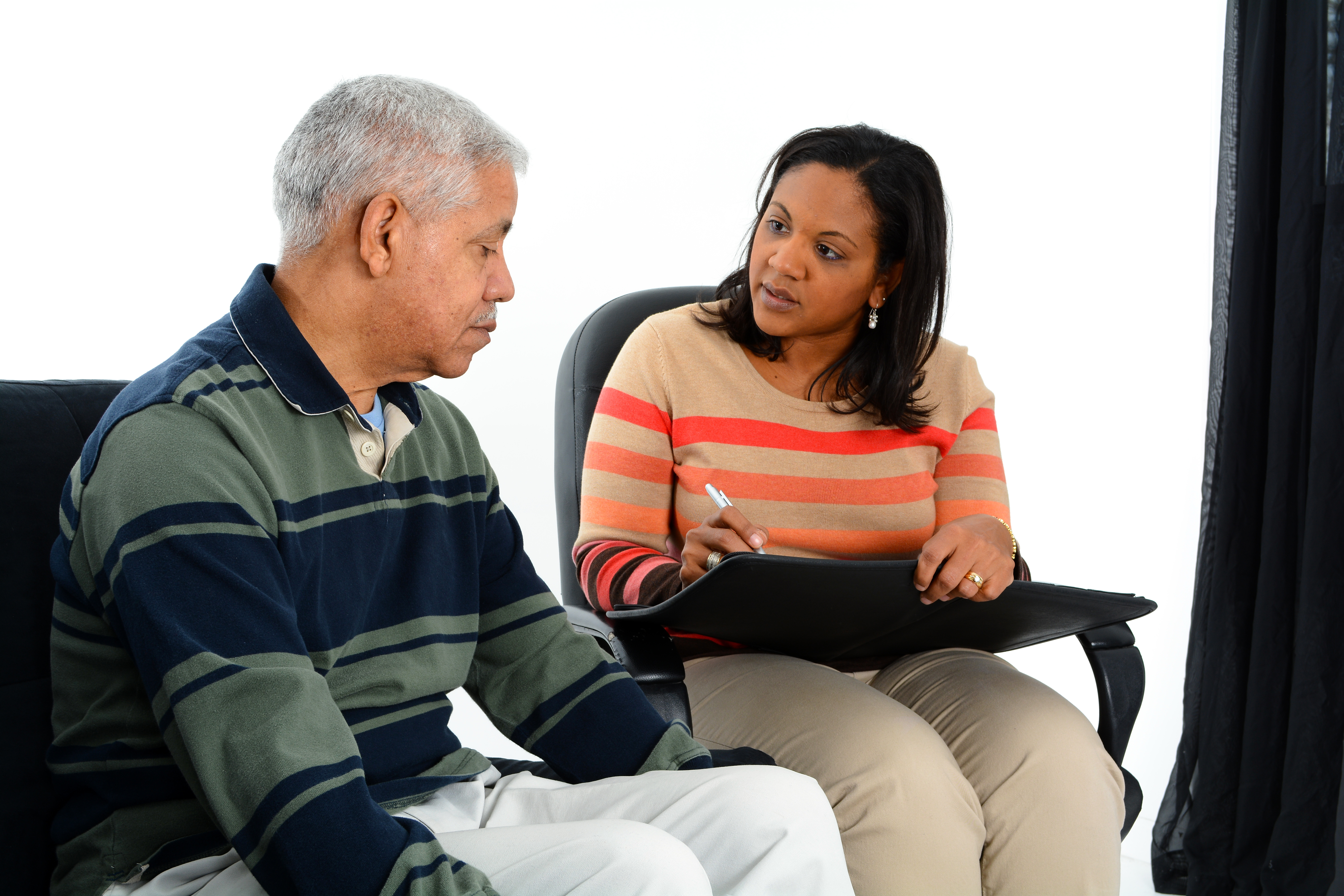 A health geriatric health professional speaking to an older adult.