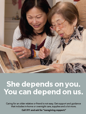 An adult-child looks through a photo album with her older mother.