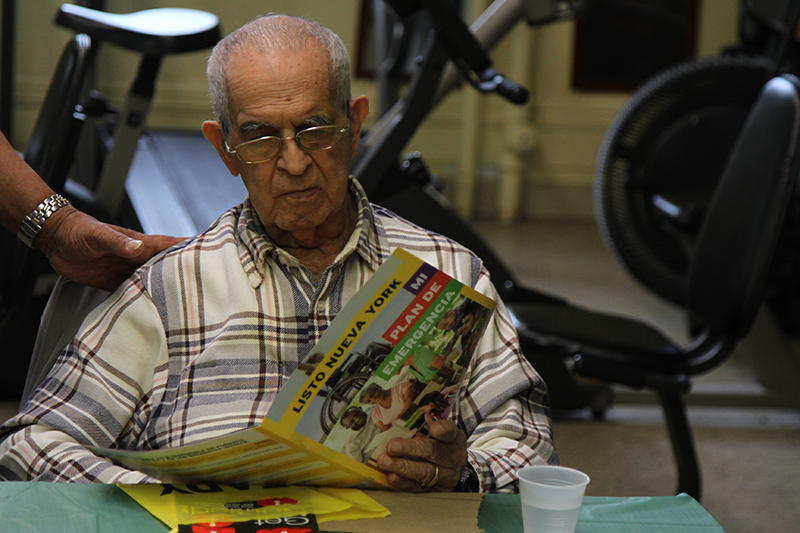An elderly man reading an emergency preparedness brochure