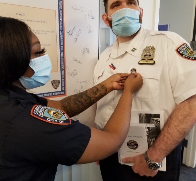 DOC Captain Cowen receives his ambassador insignia with pride.