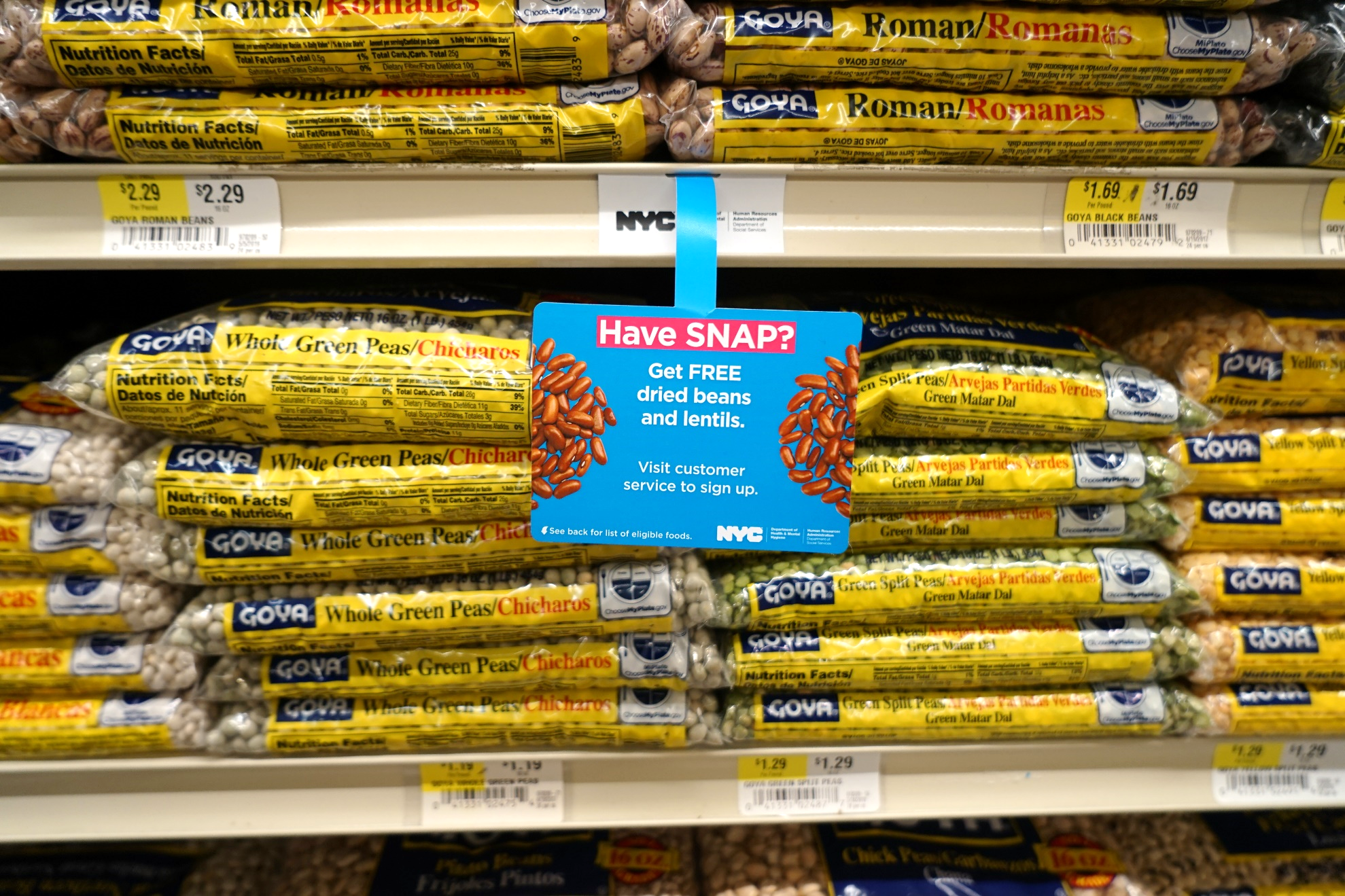 Several bags of goya beans on a grocery store shelf.