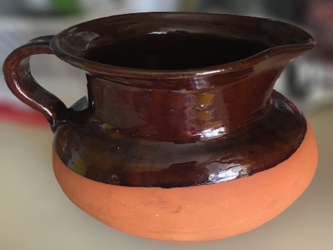A brown ceramic pitcher