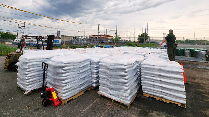 Stacks of bagged compost sit in rows on hand trucks in the parking lot of a giveback site
                                           