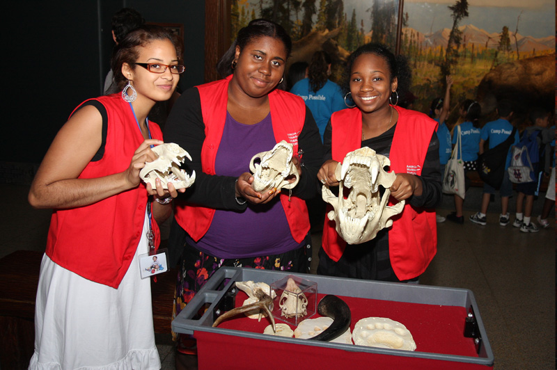 three girls holding animal bones and posing