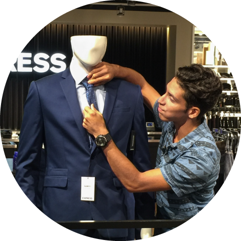 boy fixing tie on mannequin at Express clothing store