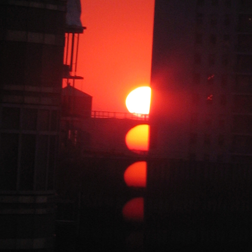 a photo of a sunset over several buildings