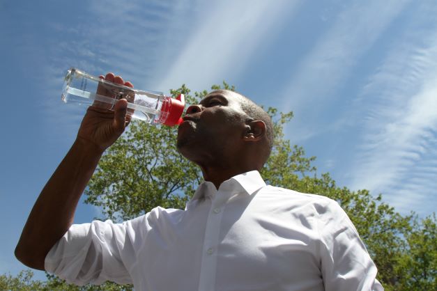 A man drinking water during extreme heat.