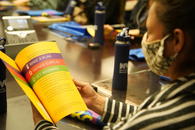 A girl scout reads a Ready NY guide during a visit to NYCEM